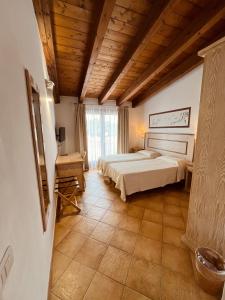 サン・パンタレオにあるHotel La Borgataの木製の天井が特徴のベッドルーム1室(ベッド1台付)