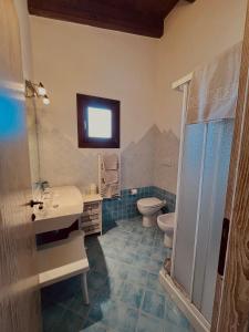 a bathroom with a sink and a toilet at Hotel La Borgata in San Pantaleo