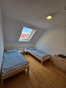 two beds in a room with a window at Ferienzimmer in Bad Mergentheim-Wachbach in Bad Mergentheim