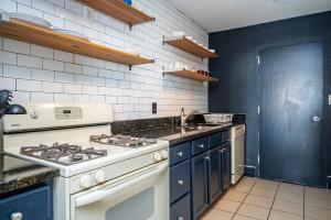 cocina con estufa blanca y armarios azules en Heart ATL Downtown High Rise 2B2B Condo LM2206 en Atlanta