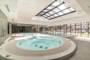 a large room with two hot tubs in a building at Nadmorski Loft GREEN PORT SPA in Kołobrzeg