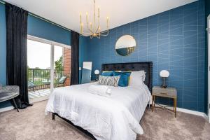 a blue bedroom with a large bed and a chandelier at Downtown New Built Roof top balcony City View 525Pkwy408 in Atlanta
