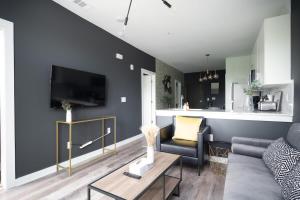 a living room with a couch and a tv on a wall at ATL Downtown New-Built Roof-top balcony City View 525#412 in Atlanta