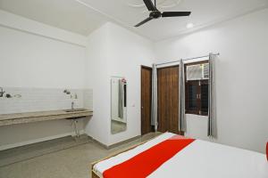 a bedroom with a bed and a sink and a ceiling fan at OYO Flagship Hotel Yuvraj Plaza in Garhi Harsāru