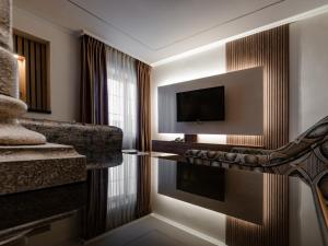 une chambre d'hôtel avec une télévision et un canapé dans l'établissement Prestige Hotel Suites - برستيج للشقق الفندقية, à Amman
