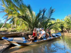 eine Gruppe von Menschen, die auf einem Boot auf dem Wasser sitzen in der Unterkunft Hide Away Bungalows in Ben Tre City in Ấp Phú Hòa (3)