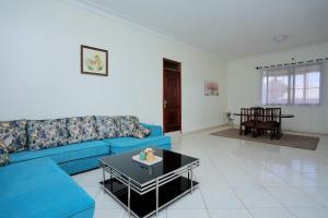 a living room with a blue couch and a table at Serene Lakeside Home in Entebbe