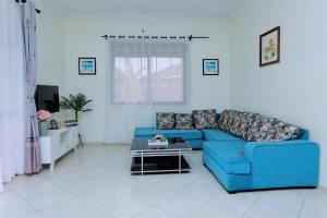 a living room with a blue couch and a table at Serene Lakeside Home in Entebbe