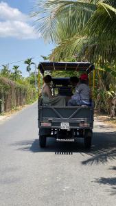 a group of people riding in a truck down a road at Hide Away Bungalows in Ben Tre City in Ấp Phú Hòa (3)