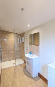 y baño con lavabo y ducha. en Torridon 1 with Private Hot Tub - Fife - Loch Leven - Lomond Hills- Pet Friendly, en Kelty