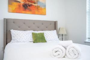 Un dormitorio con una cama blanca con toallas. en Luxe 1BR w Balcony in Downtown 542Blvd206, en Atlanta