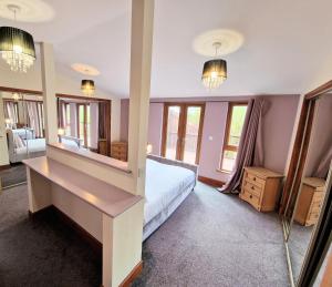 1 dormitorio con cama y espejo grande en Torridon 1 with Private Hot Tub - Fife - Loch Leven - Lomond Hills- Pet Friendly, en Kelty