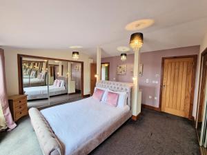 a bedroom with a large bed and a large mirror at Torridon 1 with Private Hot Tub - Fife - Loch Leven - Lomond Hills- Pet Friendly in Kelty