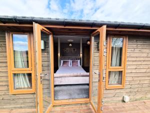 an open door of a tiny house with a bed at Torridon 1 with Private Hot Tub - Fife - Loch Leven - Lomond Hills- Pet Friendly in Kelty