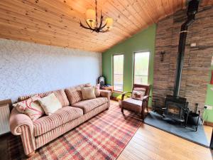 a living room with a couch and a fireplace at Torridon 1 with Private Hot Tub - Fife - Loch Leven - Lomond Hills- Pet Friendly in Kelty +8 photos