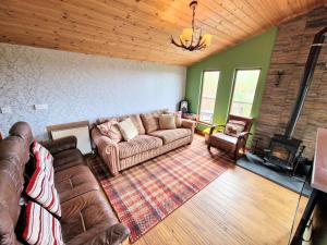 a living room with a couch and a fireplace at Torridon 1 with Private Hot Tub - Fife - Loch Leven - Lomond Hills- Pet Friendly in Kelty
