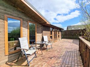 a patio with chairs and a table on a house at Torridon 1 with Private Hot Tub - Fife - Loch Leven - Lomond Hills- Pet Friendly in Kelty