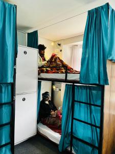 grupa osób na łóżku piętrowym w obiekcie Hostelgia w mieście Manāli