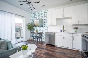 uma cozinha e sala de estar com armários brancos e uma mesa em Luxe 1BR w Balcony in Downtown 542Blvd206 em Atlanta