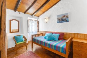 a bedroom with a bed and a chair in it at Sagres, Aloha Beach House, 500 meters from Tonel beach in Sagres