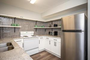 eine Küche mit weißen Schränken und einem Kühlschrank aus Edelstahl in der Unterkunft NEW ENTIRE PLACE COZY QUIET 2b2b TOWNHOUSE SP1277 in Norcross