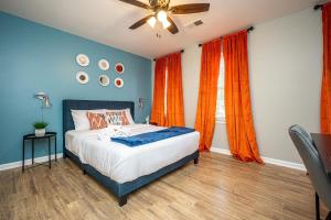 Schlafzimmer mit einem Bett mit blauen Wänden und orangefarbenen Vorhängen in der Unterkunft NEW ENTIRE PLACE COZY QUIET 2b2b TOWNHOUSE SP1277 in Norcross