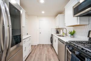 a kitchen with white cabinets and a stainless steel refrigerator at 2B1B Modern Downtown ATL Condo w 1 Free Parking LM1007 in Atlanta