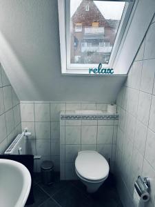 een badkamer met een toilet en een raam bij FeWo Burgnest in Bad Bentheim