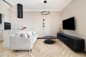un soggiorno con divano bianco e TV di EASY RENT Apartments- CityCenter Place a Lublino