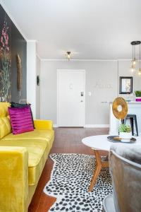 a living room with a yellow couch and a table at 2BR Chic Downtown ATL Condo w Free Parking LM602 in Atlanta