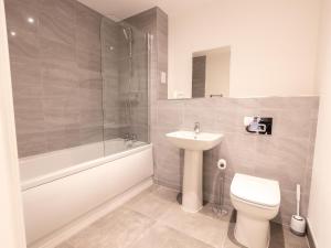 y baño con aseo, lavabo y ducha. en Pristine 1 and 2 bedroom apartments near business district by Belvilla, en Birmingham