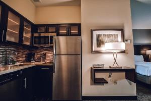 uma cozinha com um frigorífico de aço inoxidável e uma cama em Hotel Room Kitchen Free parking Washer&Dryer Gym Relux Studio Group 2 em Houston