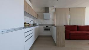 a kitchen with a red couch in a room at ESMERALDA sea front apartment in Benidorm