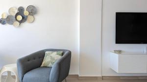 a living room with a blue chair and a tv at ESMERALDA sea front apartment in Benidorm