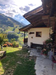 une maison avec un banc et une vue sur la vallée dans l'établissement Appartement Le Pontet Areches Beaufort, à Arêches