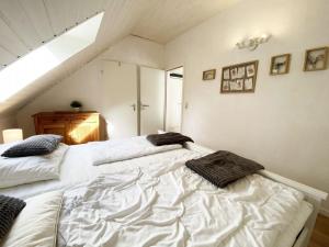 two white beds in a room with an attic at Ferien im Wangerland - Haus Wiesenweg - Ferienwohnung 1 1OG in Horumersiel