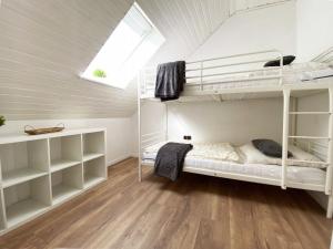 a room with two bunk beds and a window at Ferien im Wangerland - Haus Wiesenweg - Ferienwohnung 1 1OG in Horumersiel