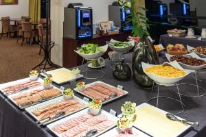 un buffet con muchos tipos diferentes de comida en una mesa en Hotel Panorama en Vilna