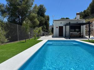 a villa with a swimming pool and a house at La Casona del Pinar Swiming Pool in Alhaurín de la Torre