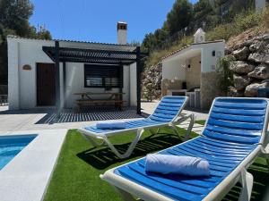two blue and white chairs sitting next to a swimming pool at La Casona del Pinar Swiming Pool in Alhaurín de la Torre