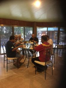 un grupo de personas sentadas en una mesa en un restaurante en M&A Riverside Beach Bungalows, en Chol