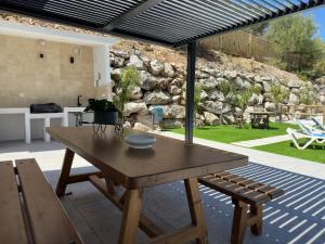 a wooden table and a bench on a patio at La Casona del Pinar Swiming Pool in Alhaurín de la Torre +51 photos