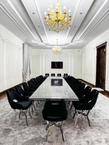 a conference room with a table and black chairs at De Villa Hotel in Samarkand
