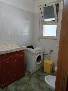 a bathroom with a washing machine and a sink at Casa Beatrice in Specchiolla