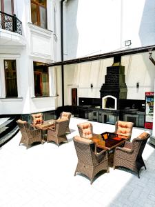 a patio with chairs and a table and a fireplace at De Villa Hotel in Samarkand
