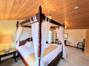 1 dormitorio con cama con dosel y techo de madera en Lomond 3 with Private Hot Tub - Fife - Loch Leven - Lomond Hills -Pet Friendly, en Kelty
