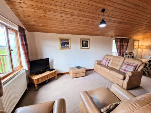 a living room with a couch and a tv at Lomond 3 with Private Hot Tub - Fife - Loch Leven - Lomond Hills -Pet Friendly in Kelty