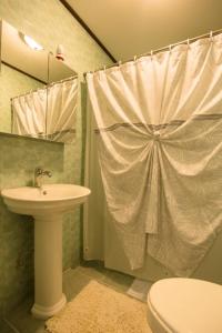 een badkamer met een wastafel, een toilet en een douche bij M&A Riverside Beach Bungalows in Chol