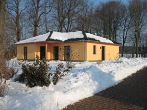 ein kleines gelbes Haus mit Schnee auf dem Boden in der Unterkunft Ferienhaus für 6 Personen ca 128 m in Sanitz, Ostseeküste Deutschland Landkreis Rostock in Sanitz