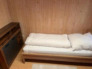 Cama en habitación con pared de madera en Urige idyllische Hütte mit Sauna, en Grainet